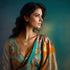 A woman with long dark hair gazes to the side, wearing a floral-patterned sari in shades of teal, orange, and gold. She adorns a delicate 14k gold pendant from the "Boy and Girl Children Pendant Hearth Necklace for Mothers Day" collection and stands against a muted green and blue background.